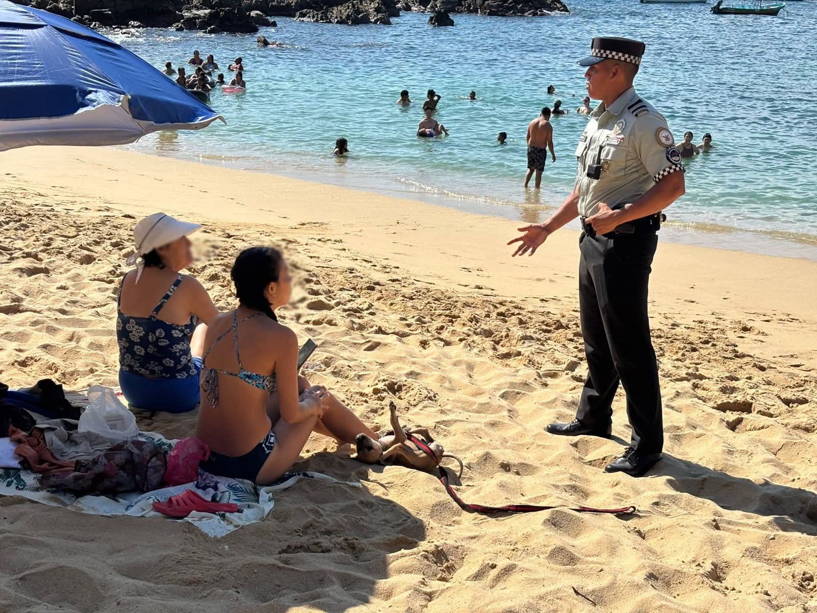 policia hablando con turistas en la playa