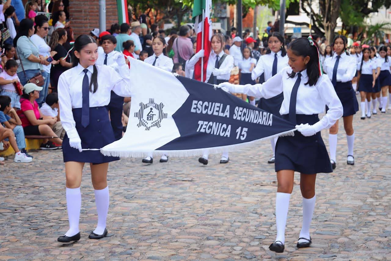 niñas sosteniendo un banderin de la escuela