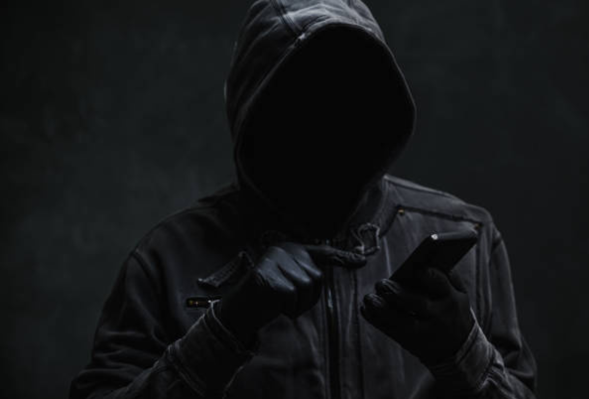 persona vestida de negro y con un telefono en la mano